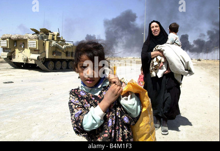 La guerra di Iraq Marzo 2003 locali fuggire la masterizzazione di città di Bassora in Iraq come elementi di blindati della Royal Scots Dragoon Guards raggiungere le gonne fuori della città Foto Stock