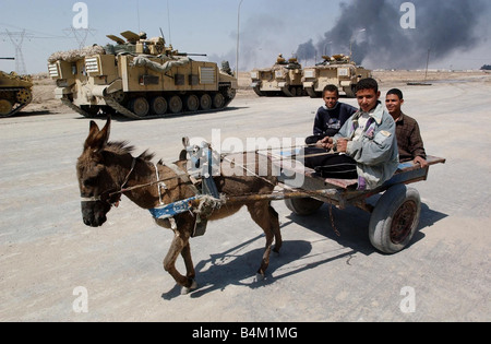 Iraq guerra 2003 locali fuggire la masterizzazione di città di Bassora in Iraq meridionale come elementi di blindati della Royal Scots Dragoon Guards raggiungere le gonne fuori della città Foto Stock