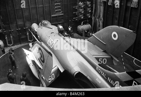 Esercitazione NATO 1965 HMS Ark Royal Portaerei Marzo 1965 Un Supermarine Scimitar è preparata prima di bing sollevato sul ponte di volo della Royal Navy portaerei La Ark Royal Mirrorpix Foto Stock