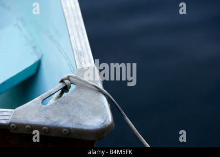 La prua di una vecchia blu pallido esterno in metallo motoscafo su un lago all'alba. Foto Stock