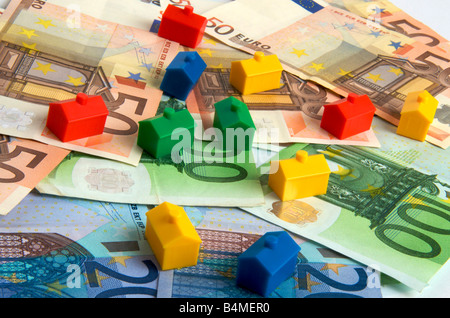 Case in miniatura sulle banconote in euro, immagine simbolica dei prezzi immobiliari in Europa Foto Stock