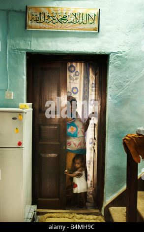 La madre e il bambino nella porta a dimora in Stone Town Zanzibar Tanzania Africa la scalinata conduce ai piani aggiuntivi Foto Stock