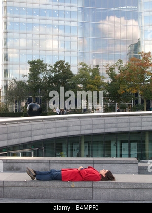 Una donna rilassante per appoggio in una posizione inusuale in più lo sviluppo di Londra, Southwark, Londra Foto Stock