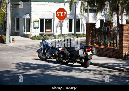 Due moto parcheggiata da un segnale di stop nel piccolo centro America Foto Stock