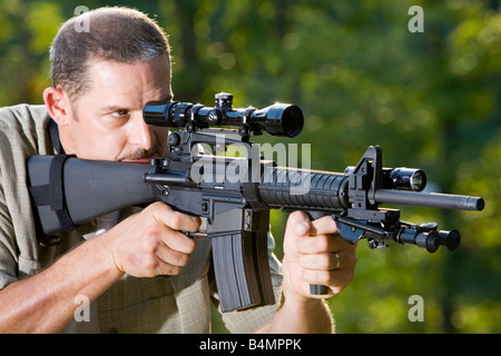 Un uomo si prefigge un AR 15 Bushmaster fucile. Foto Stock