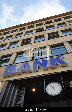 Segno della banca su un edificio e un orologio che mostra da cinque a dodici Foto Stock