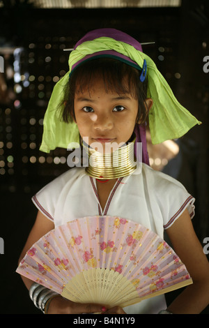 Ritratto di una giovane ragazza Giraffa con una ventola di circa 300 profughi birmani in Thailandia sono membri del gruppo indigeno noto come Longnecks il più grande dei tre villaggi dove la Longnecks live è chiamato Nai Soi situato vicino a Mae Hong Son City Longnecks usura degli anelli di metallo sul loro collo che spingono la clavicola verso il basso e si estendono il collo sono una attrazione turistica turisti visitano Nai Soi per scattare foto di Longnecks e comprare il loro artigianato i villaggi sono criticati dalle organizzazioni per i diritti umani come umana giardini zoologici Foto Stock