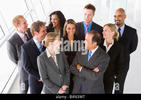 Gruppo di collaboratori in piedi in uno spazio ufficio sorridente (high key) Foto Stock