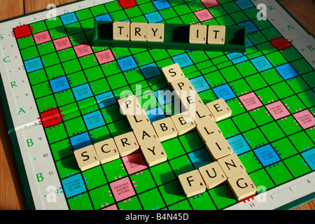 Scheda di Scrabble con piastrelle lettera - che vi invitano a giocare e migliorare le vostre competenze ortografiche. Foto Stock