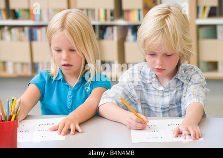 Due studenti nella classe di lettere di apprendimento Foto Stock