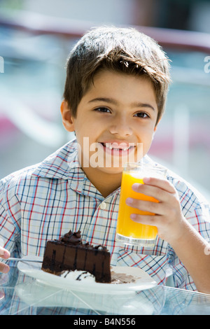 Giovane ragazzo al ristorante a mangiare il dessert e sorridente (messa a fuoco selettiva) Foto Stock