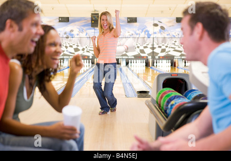 Donna bowling con gli amici Foto Stock