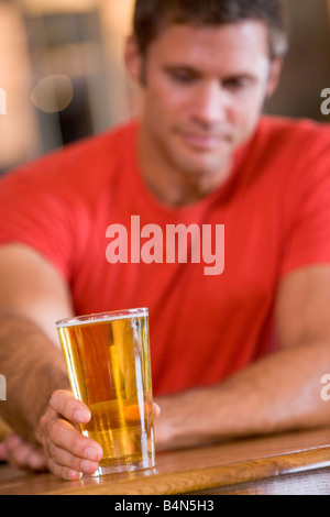 L'uomo avente un bicchiere di birra Foto Stock