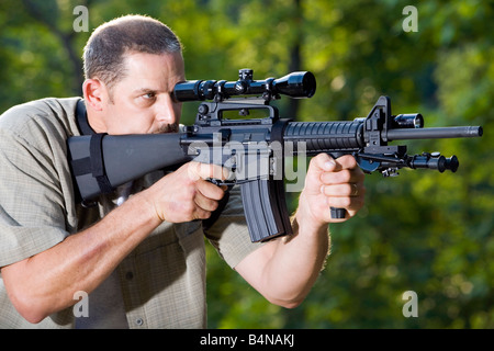 Un uomo si prefigge un AR 15 Bushmaster fucile. Foto Stock