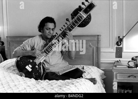 Ravi Shankar giocando il sitar nella sua suite presso il Savoy Hotel seduta sul letto Ottobre 1969 Foto Stock