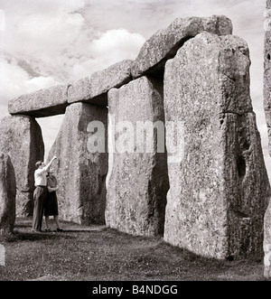 Uno di Gran Bretagna s più famosi e misteriosi monumenti antichi di Stonehenge sulla Piana di Salisbury Wiltshire una coppia giovane guardare il monumento dove Druid pellegrini venuti per adorare durante il Solstizio d'estate Foto Stock