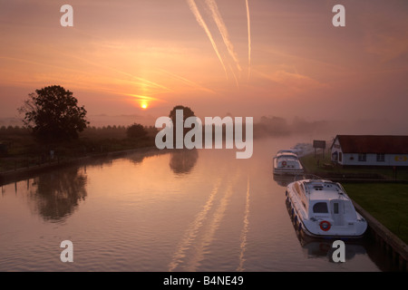 Il fiume Bure al sorgere del sole in una nebbiosa mattina visto da Acle Ponte sul Norfolk Broads Foto Stock