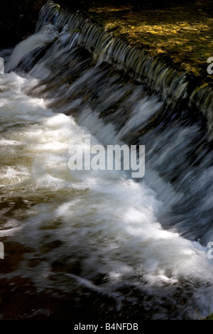 Close up di stramazzo di aspirazione sul serbatoio con acqua andando a piccola scala idro centrale elettrica Cynwydd Galles del Nord Foto Stock