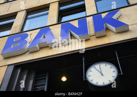 Segno della banca su un edificio e un orologio che mostra da cinque a dodici Foto Stock