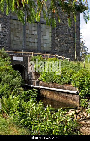 Acqua corsa di coda da Cwm Dyli hydro potenza elettrica turbine hall dopo la generazione di elettricità Snowdonia Foto Stock