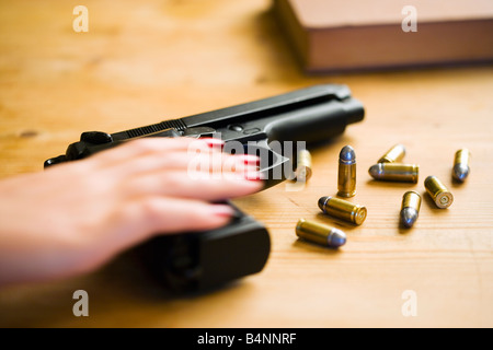 La mano di raggiungere per Beretta 92F pistola con munizioni 9 mm Foto Stock