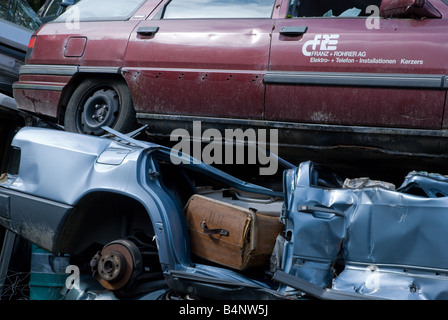 Junkyard : fracassato, frantumato autovetture e autobus a sedersi in un junkyard Foto Stock