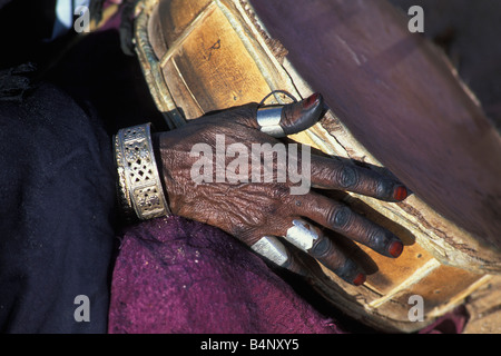 Algeria vicino Djanet Tuareg annuale festival denominato SBIBA Donna suonare il tamburo Close up deserto del Sahara Foto Stock