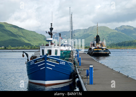 Tradizionali di piccole barche da pesca ormeggiate ad un pontile in legno su un scozzese loch Foto Stock