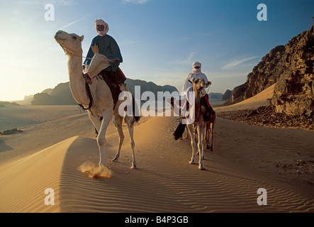 Algeria, vicino Djanet, gli uomini della tribù Tuareg e camel caravan. Deserto del Sahara. Foto Stock