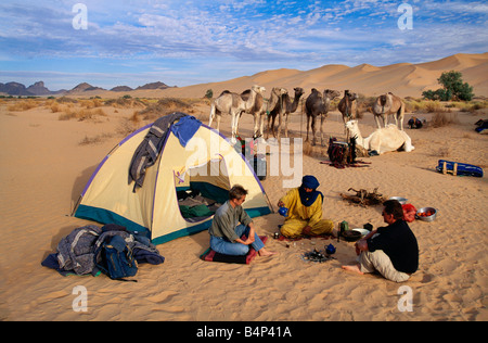 Algeria Djanet turisti donna e uomo avente tè con il popolo Tuareg deserto del Sahara Foto Stock