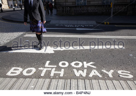 Guardare in entrambe le direzioni segno sulla strada con uomo in kilt Foto Stock