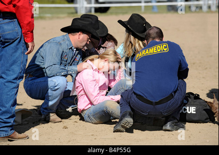 Rodeo femmina riceve attenzione medica dopo la caduta del cavallo Foto Stock