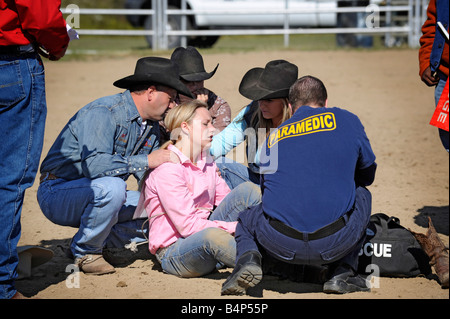 Rodeo femmina riceve attenzione medica dopo la caduta del cavallo Foto Stock