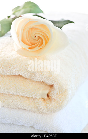 Pila di soffici asciugamani di lusso con fiori freschi Foto Stock
