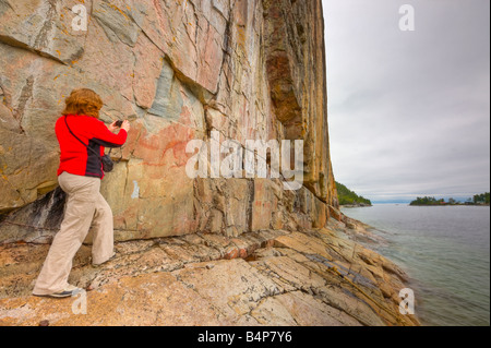 Visualizzazione turistica antichi pittogrammi sul Agawa Rock, rock Agawa pittogrammi Trail, Lago Superior parco provinciale Foto Stock