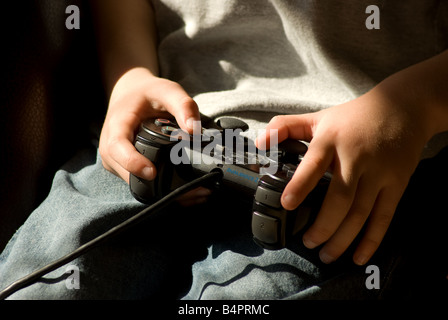 In prossimità del boy utilizzando un controller di Playstation Foto Stock