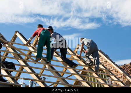 Costruttori di costruire il tetto di una casa Foto Stock
