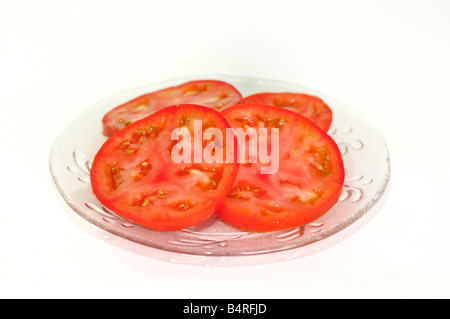 Home organico-cresciute fette di pomodoro fresco su un taglio chiaro-piastra di vetro. Primo piano. Foto Stock