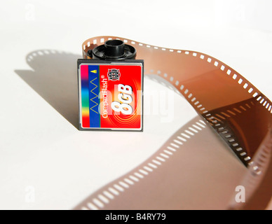 Scheda Compact flash disteso di fronte a una pellicola di 35mm a cassetta con una striscia di pellicola negativa e la sua ombra su di esso. Foto Stock