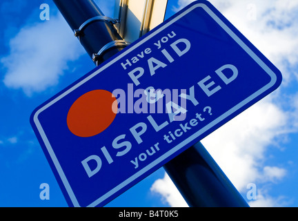 Pagare e Display segno attaccato ad un posto in un parcheggio con cielo blu dietro Foto Stock