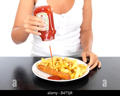 Giovane donna con salsiccia e patatine modello rilasciato Foto Stock