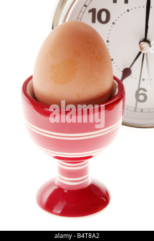 Cucinata fresca sana colazione uova sode o in un uovo rosso tazza isolata contro uno sfondo bianco con nessun popolo e un tracciato di ritaglio Foto Stock