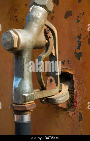 Vecchia ruggine pompa carburante con spiderwebs crescente sull'ugello Foto Stock