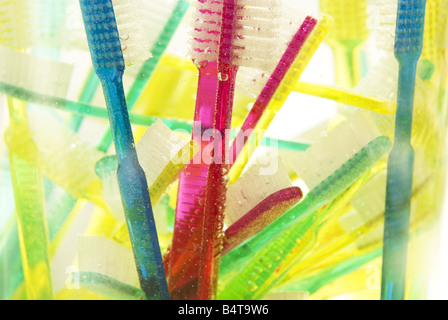 Close up sommerse e floating vivacemente colorato spazzolini da denti in vaso di vetro Foto Stock