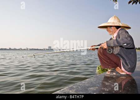 Pescatore solitario West Lake Hanoi Vietnam del nord Foto Stock