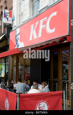 Gruppo di persone a mangiare all'aperto tabella KFC Preston city centre Lancashire England Regno Unito Foto Stock