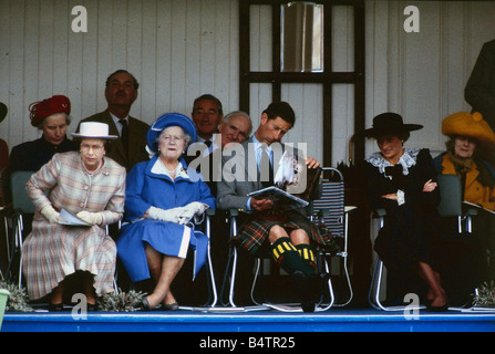 La regina Elisabetta 11 settembre leaing in avanti nella sua sede sul podio a Braemar Highland Games Regina madre guarda mentre il Principe Charles legge un libro guardato dalla Principessa Diana C T Roy Brit Regina Scozia n.8 Foto Stock