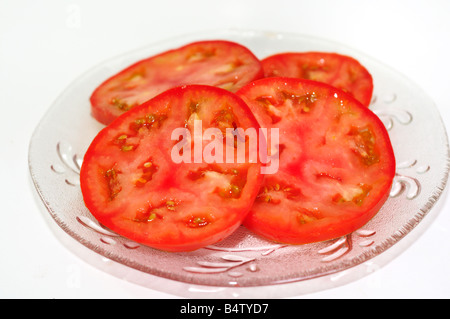 Home organico-cresciute fette di pomodoro fresco su un taglio chiaro-piastra di vetro. Primo piano. Foto Stock