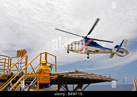 Atterraggio elicottero su offshore produzione marino oil rig con equipaggio cambio olio lavoratori, off costa del Gabon, Africa occidentale Foto Stock