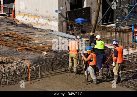 Costruzione / lavoratori edili versare cemento su un sito di costruzione.Melbourne Victoria Australia. Foto Stock